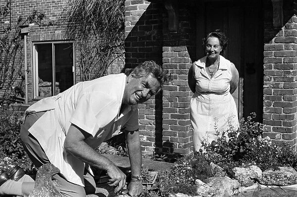 Denis Healey at work on a fishpond in his garden at his home in the Sussex countryside