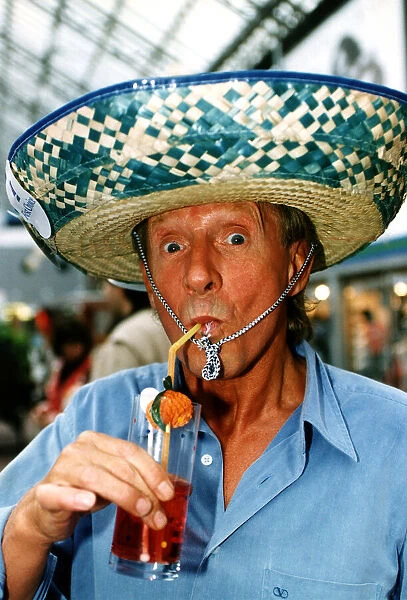Denis Law enjoying a refreshing drink, wearing a sombrero. 12th August 1994