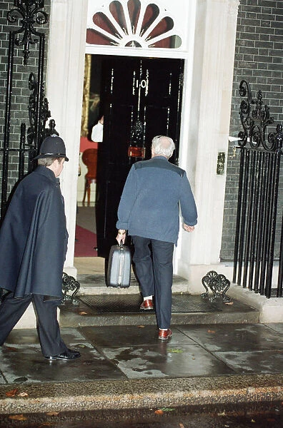 Denis Thatcher carries a suitcase into 10 Downing Street following the Prime Minister