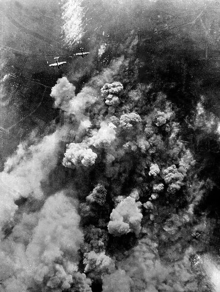 Dense smoke rising from the hail of bursting bombs as Avro Lancaster bombers of RAF