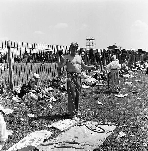 Derby Day at Epsom. Pictured, a strong man prepares to wrap himself in chains