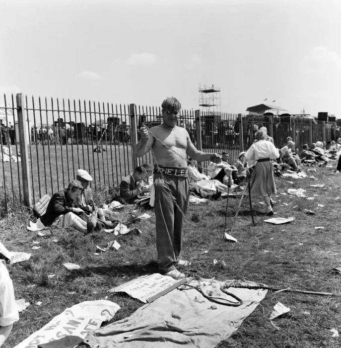 Framed Print : Derby Day at Epsom. Pictured, a strong man prepares to wrap himself in chains Framed Print : Derby Day at Epsom. Pictured, a strong man prepares to wrap himself in chains