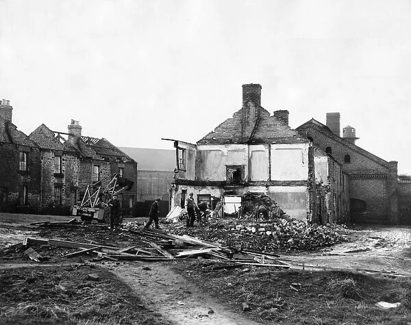 Derelict housing in an area of Stanley - workmen clear the site