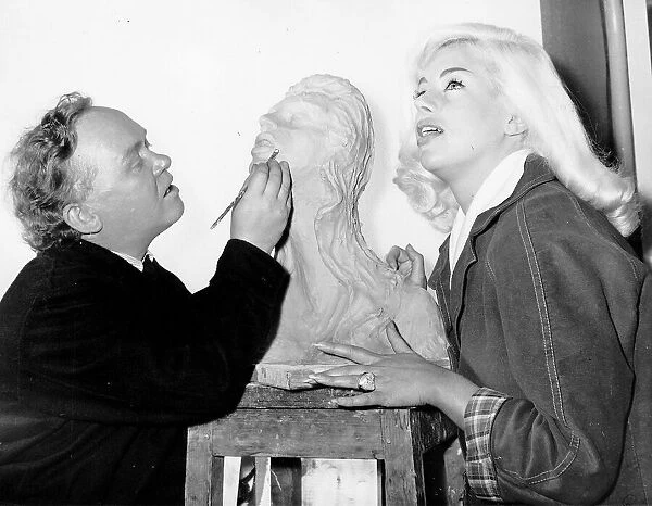 Diana Dors models for a sculpture by Charlie Drake in his dressing room at Boreham Wood