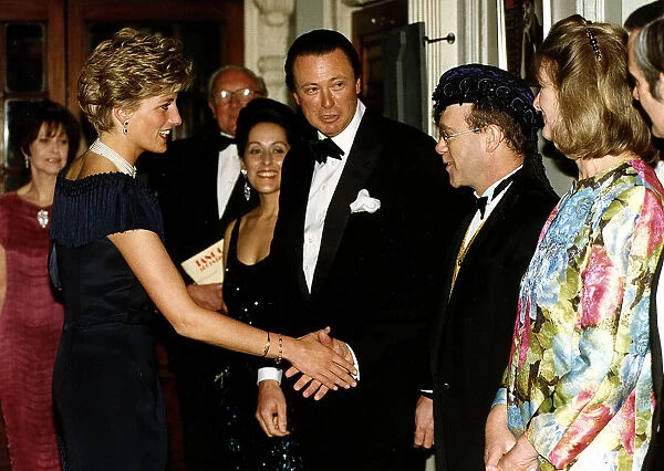 Diana, Princess of Wales is greeted by singer Elton John for a charity performance of