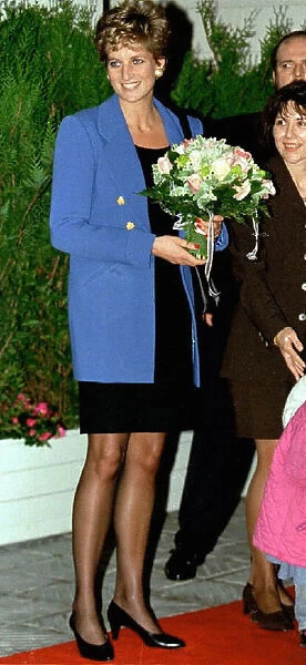 Diana, Princess of Wales, receives a bouquet of flowers from an unidentified girl as she