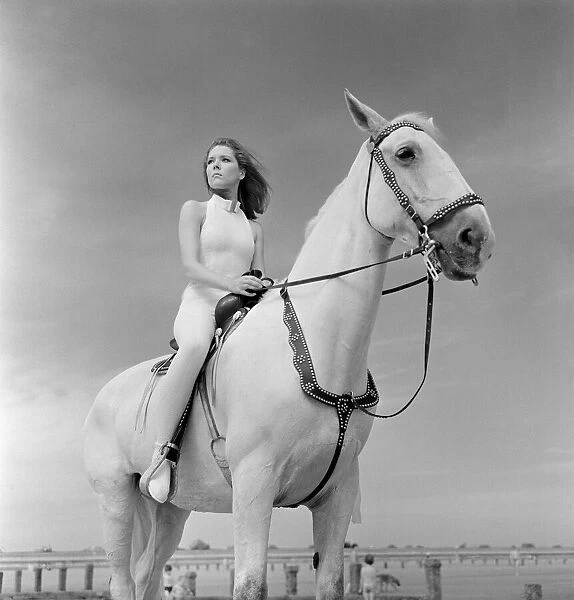 Diana Rigg, who plays Emma Peel, sitting on a white horse on the beach at St Mary