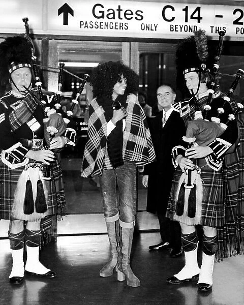 Diana Ross on arrival in Scotland is greeted by two pipers. 1st October 1973