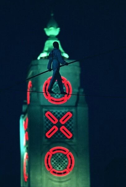 Didier Pasquette a tightrope walker silhouetted against the Oxo Tower in action above