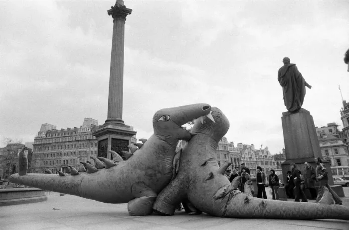 Framed Print : Two dinosaurs as high as a double decker bus fight each other in London Framed Print : Two dinosaurs as high as a double decker bus fight each other in London