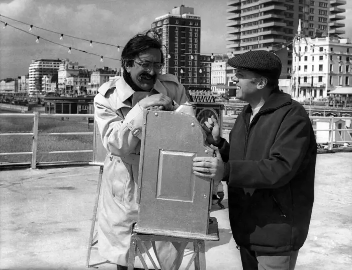 Framed Print : Director Richard Attenborough and producer-writer Len Deighton relax during a break in