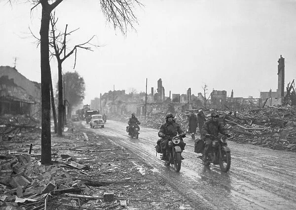 Dispatch riders make their way through a ruined French town as the Allied forces push