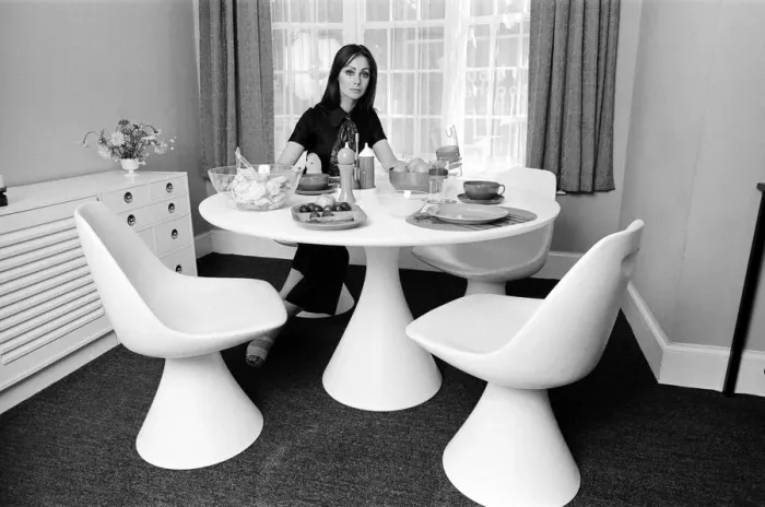 Framed Print : A display of modern furniture, a woman sitting in a modern dining room space