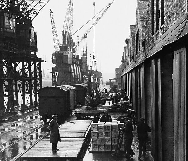 Dockers busy unloading cargo at Cardiff Docks, a port in southern Cardiff, Wales
