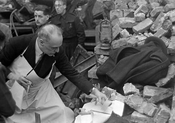 A doctor prepares his instruments while rescue workers search the rubble following