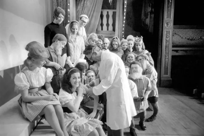 Framed Print : A doctor with his syringe makes ready to give anti-flu vaccine to Margaret Ayre