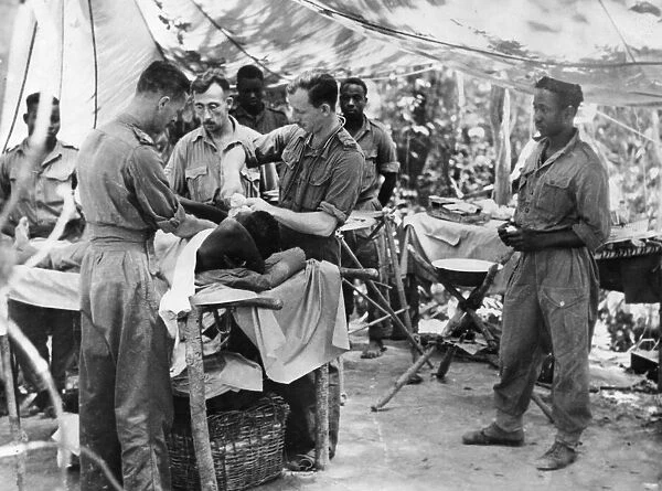 Doctors tend a wounded soldier of the 81st West African Division in an improvised