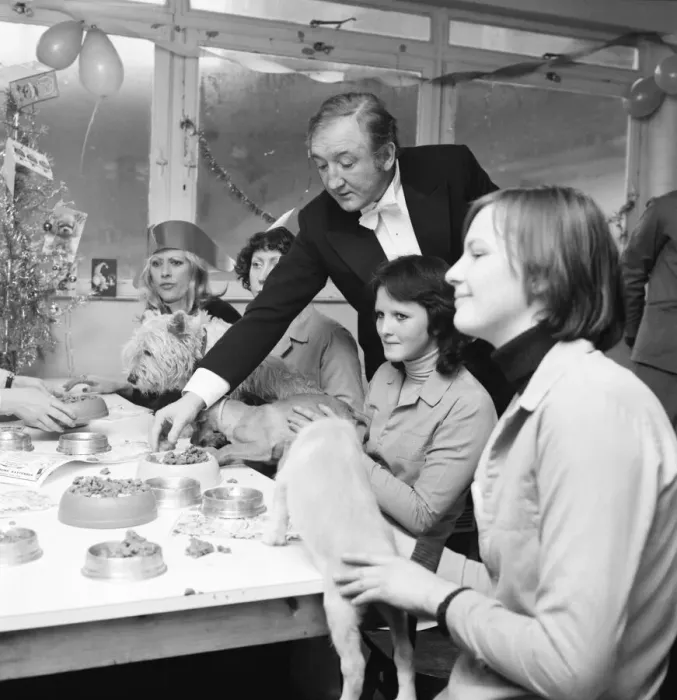 Framed Print : Dog Owners and their pets seen here having a Christmas party as actor Ronald Fraser acts Framed Print : Dog Owners and their pets seen here having a Christmas party as actor Ronald Fraser acts