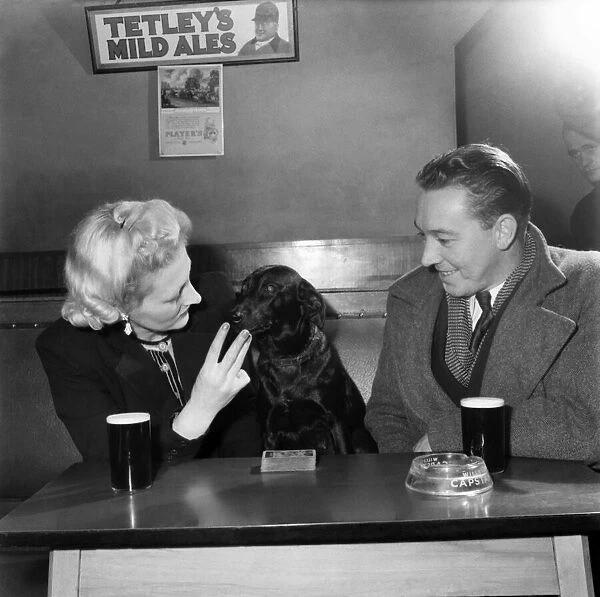 Dog Working behind Tite Bar, sitting with customers at a table February 1953
