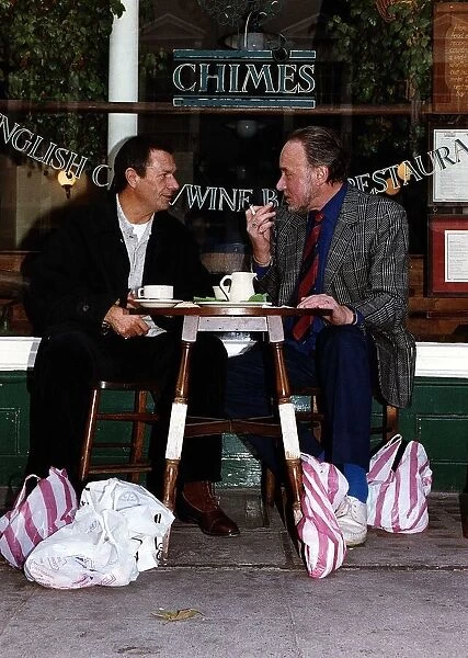 Don Henderson Actor & Michael Elphick actor sitting at pavement cafe table with shopping