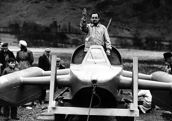 Donald Campbell in Bluebird speedboat at Ullswater stands in craft raises hand smokes