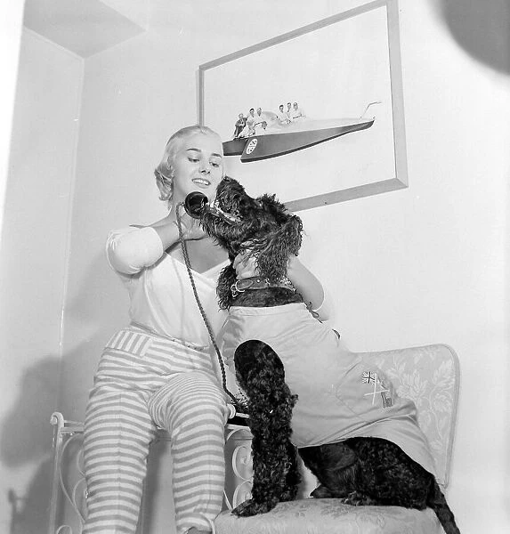 Dory Swan and her pet dog talking on the telephone Circa 1955