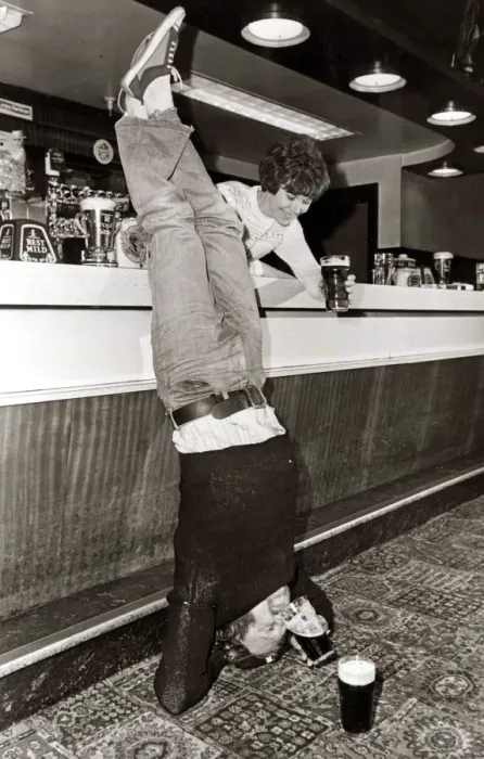 Framed Print : Drinking - A man doing a headstand in his local pub drinking his pint of beer upside down