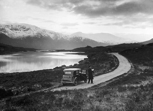 Driver consults his map whilst parked beside Loch Cluanie, Inverness shire