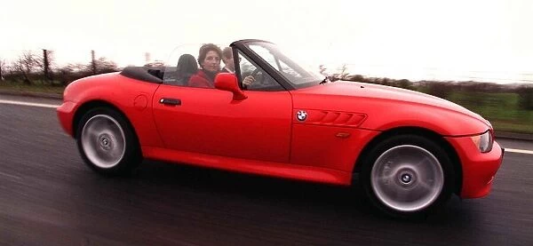 Driving an open top BMW red car