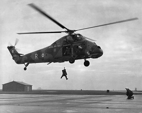 Dry winching drill. A Westland Wessex HC2 helicopter of 75 Squadron which is standing in