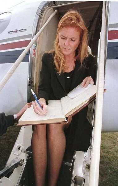 Duchess of York Sarah Ferguson signs the visitors book at the airport before her flight
