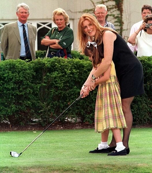 The Duchess of York teaches her daughter Princess Eugenie golf during the charity