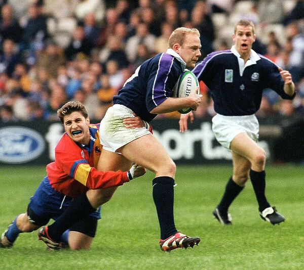 Duncan Hodge holds ball for Scotland October 1999 as he is tackled by Andrei Kovalenco of
