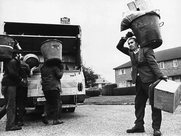 Dustbin men doing their rounds in the city of Cambridge. Circa 1970s