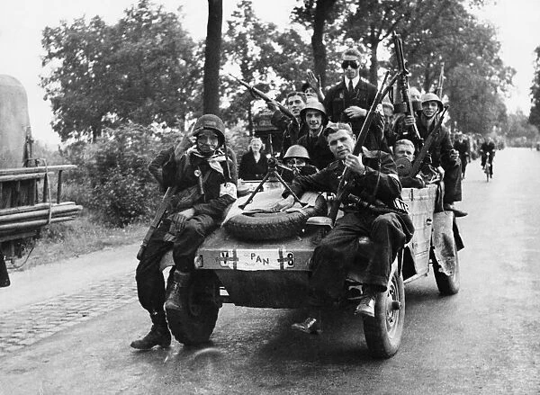 Dutch forces of the interior called P. A. N. crowd on to a captured German car in Eindhoven