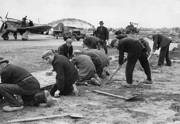 Dutch workmen help repair a dispersal at Volkel, Holland