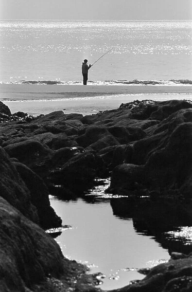 Ebbw Vale, Wales. Sea angler tries his luck off the mumbles of Ebbw Vale, 11th March 1971