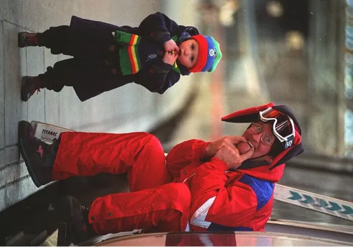 Framed Print : Eddie Edwards in red ski suit, Eddie the Eagle Edwards making friends with 2 year old