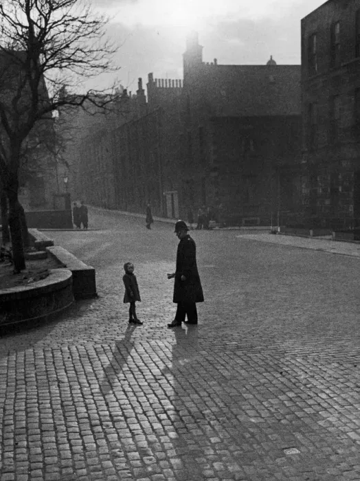 Framed Print : Edinburgh street scenes, Policeman talking to lost child on a cobbled street in Framed Print : Edinburgh street scenes, Policeman talking to lost child on a cobbled street in