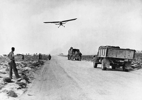 El Hamma road serves as impromptu airfield. A Stimson aircraft takes off from the road