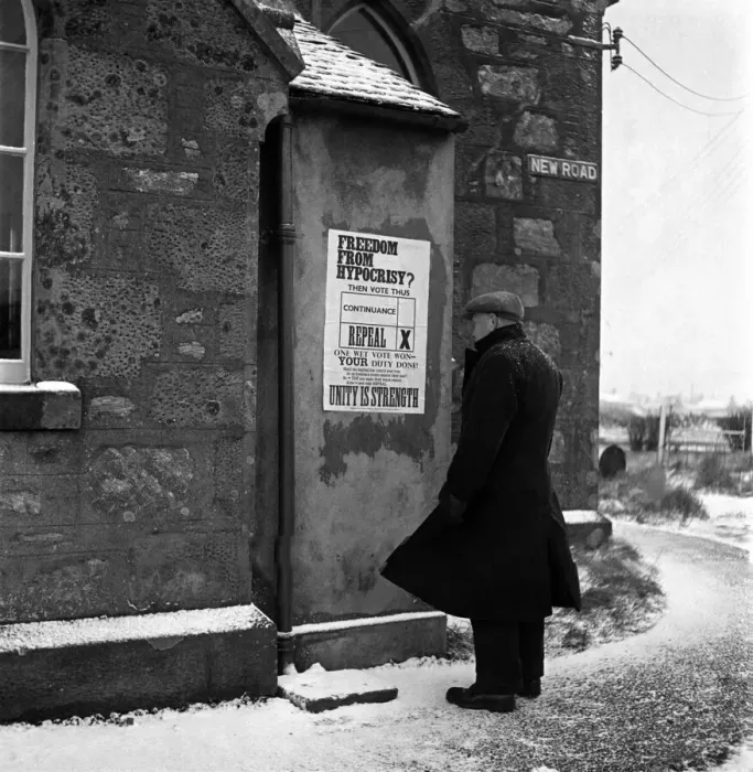 Framed Print : An elderly man reading a notice put up on the wall of his local church in Scalloway Framed Print : An elderly man reading a notice put up on the wall of his local church in Scalloway