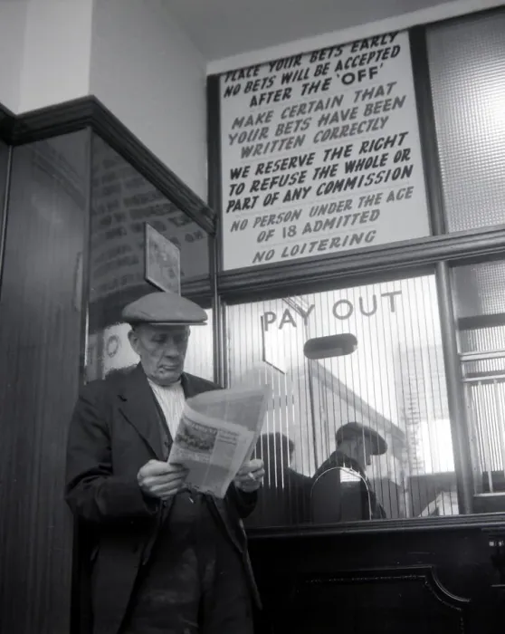 Framed Print : An elderly man studies the form guide inside A E Fane and Co betting shop in Islington Framed Print : An elderly man studies the form guide inside A E Fane and Co betting shop in Islington