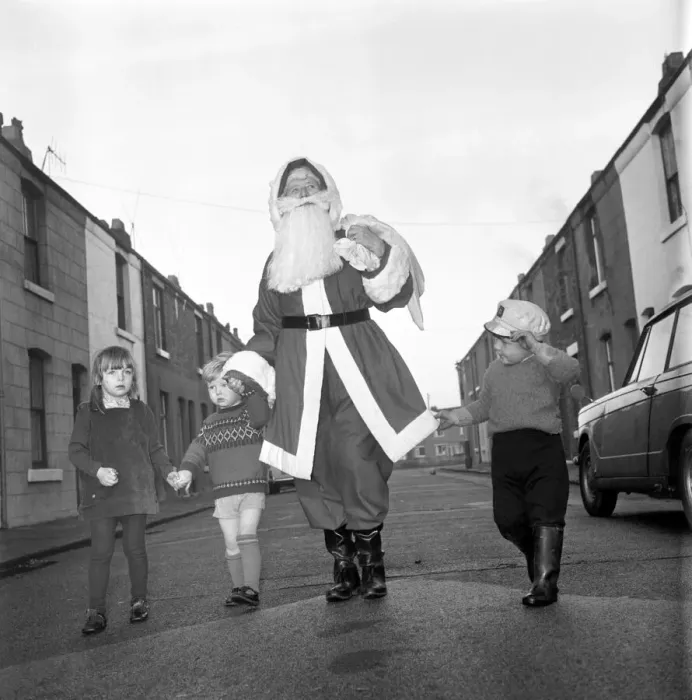 Framed Print : An elderly woman dressed as Santa Claus on her way to an engagement accompanied by