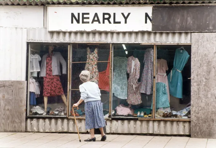 Framed Print : An elderly woman pauses to look at the World War Two prefab shop on the corner of Framed Print : An elderly woman pauses to look at the World War Two prefab shop on the corner of