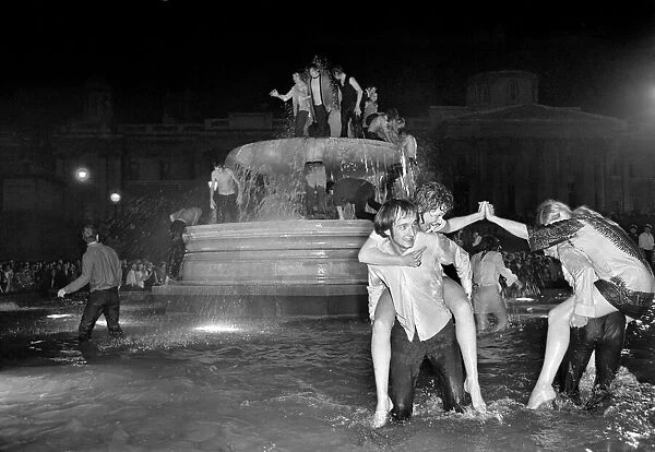 Election night scene in Trafalgar Square. Revellers celebrating in the fountains after