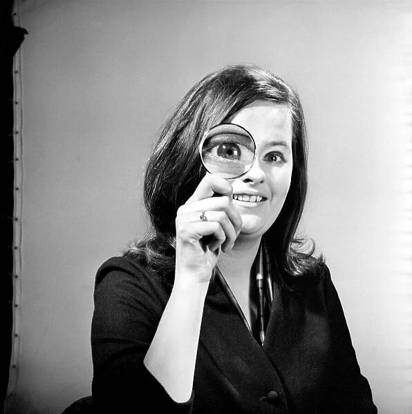 Elementary my dear Watson. Woman holding magnifying glass. Model: Jennie Cropper
