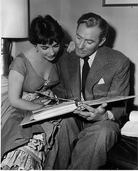 Elizabeth Taylor with husband Michael Wilding look through a photograph album from their