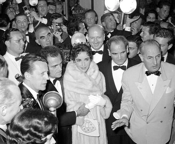 Elizabeth Taylor and husband Mike Todd surrounded by photographers in the theatre before