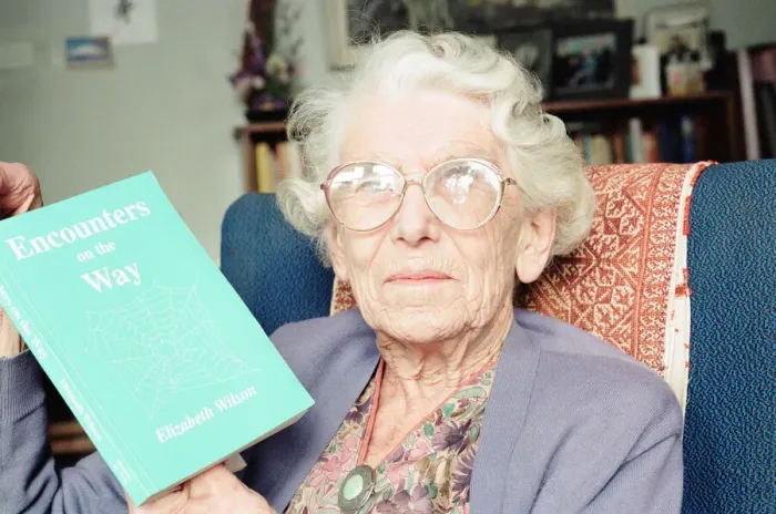 Framed Print : Elizabeth Wilson, Author with a copy of her book, Encounters on the Way, Circa 1998