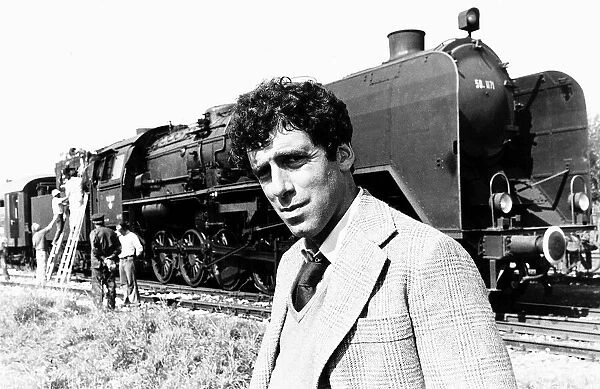 Elliott Gould actor standing in front of a steam train in a scene from the film The Lady
